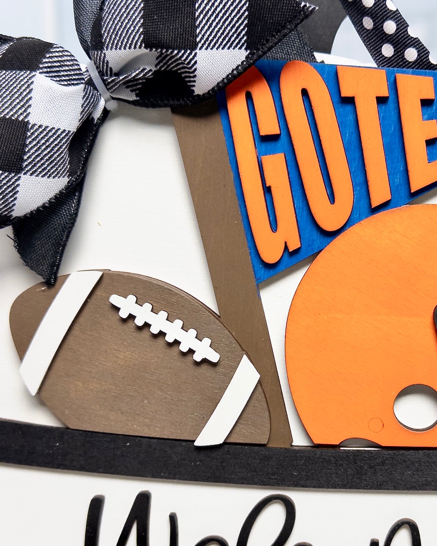Decorative items including a football, checkered ribbon, and letter 'G' on a white background
