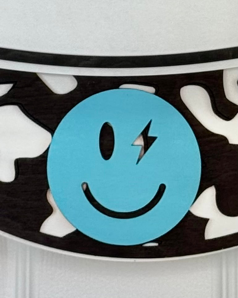 Close-up of a blue smiley face design on a black and white patterned background