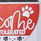 Product packaging with 'Welcome' and paw prints on a red background