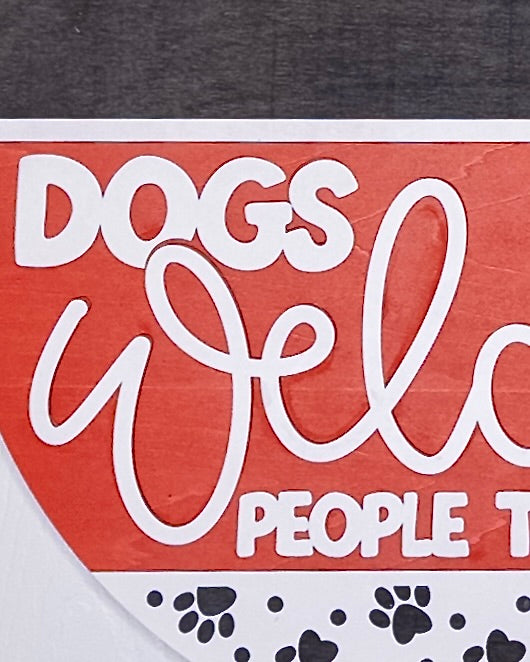 Text 'DOGS Welcome PEOPLE Tolerated' on a red and gray background with paw prints.