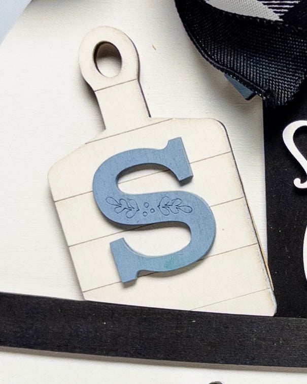 Decorative letter 'S' on a white background with black trim