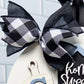 Decorative wreath with a black and white checkered bow on a white background