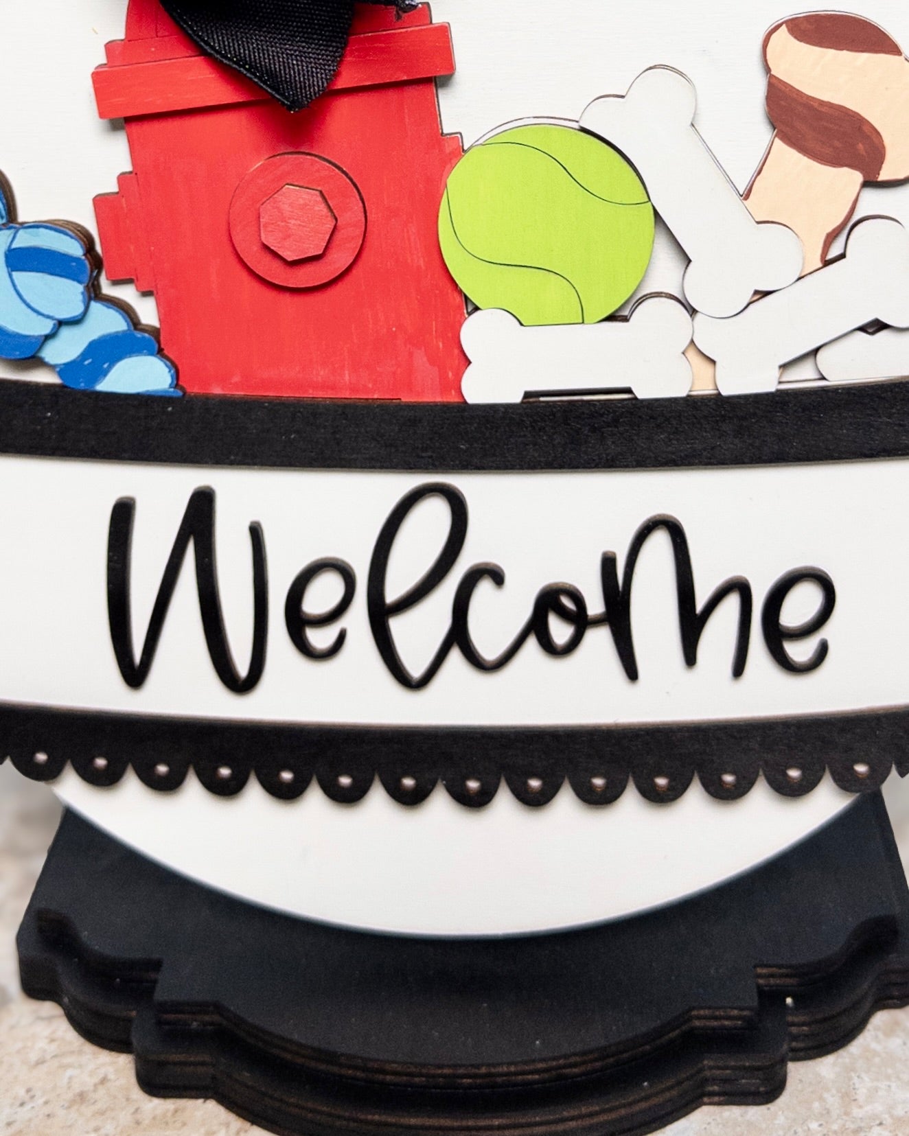Decorative sign with cartoon characters and the word 'Welcome' on a white background
