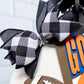 Black and white checkered bow with football and 'GO' sign on a light blue background