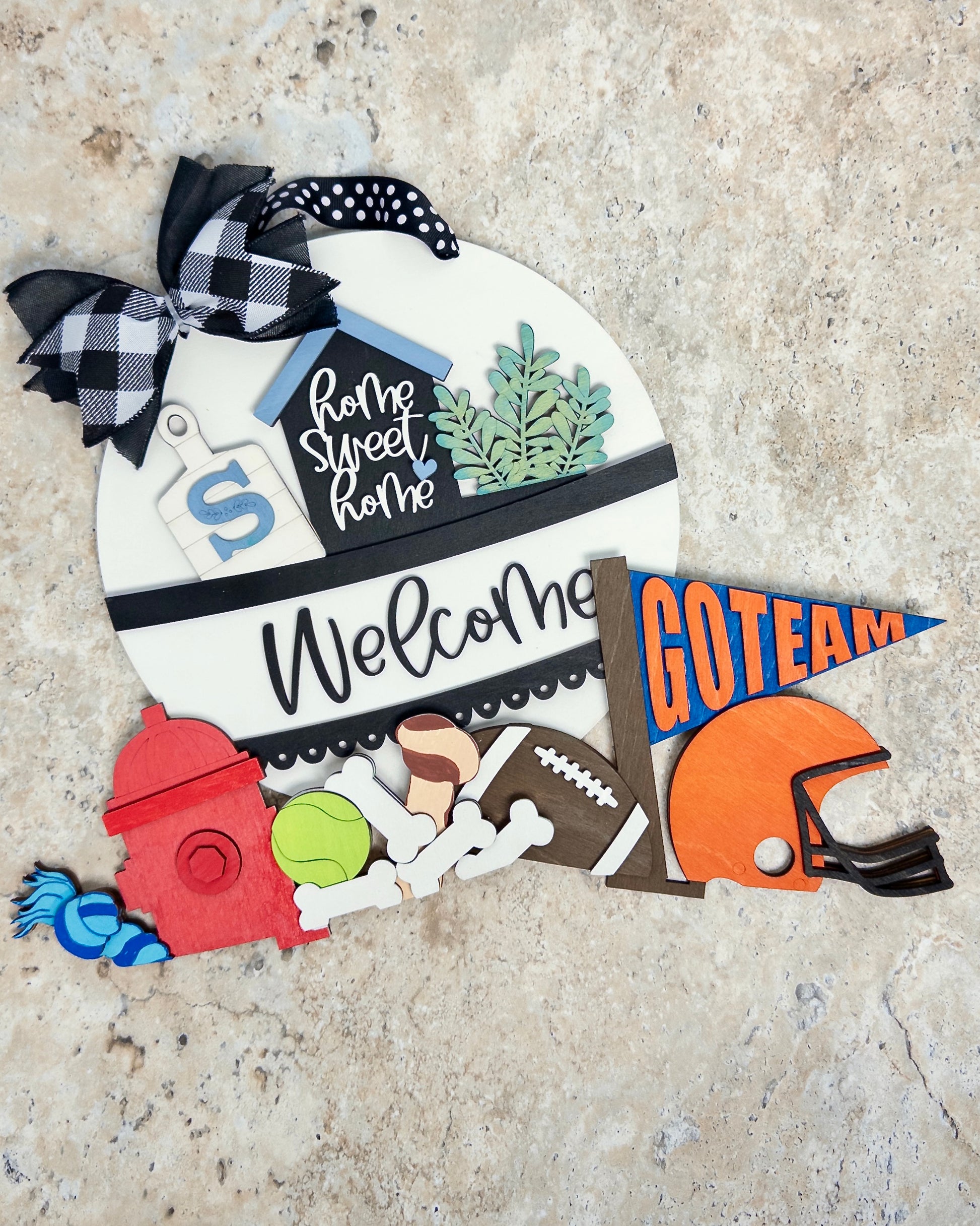 Decorative sign with sports-themed elements and text on a textured surface