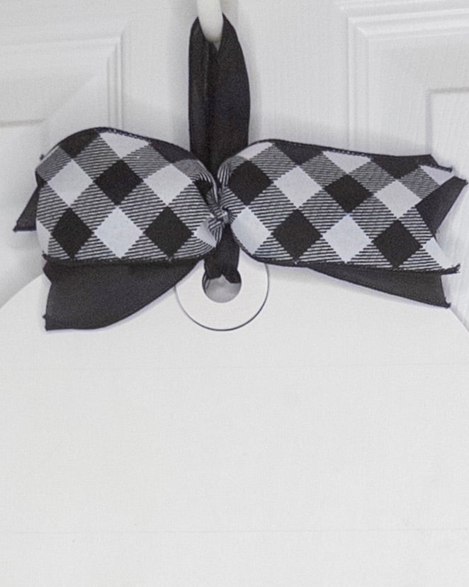 Black and white checkered bow on a white door