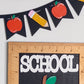 Decorative banner with apples and pencils next to a ruler with 'SCHOOL' text on a white background