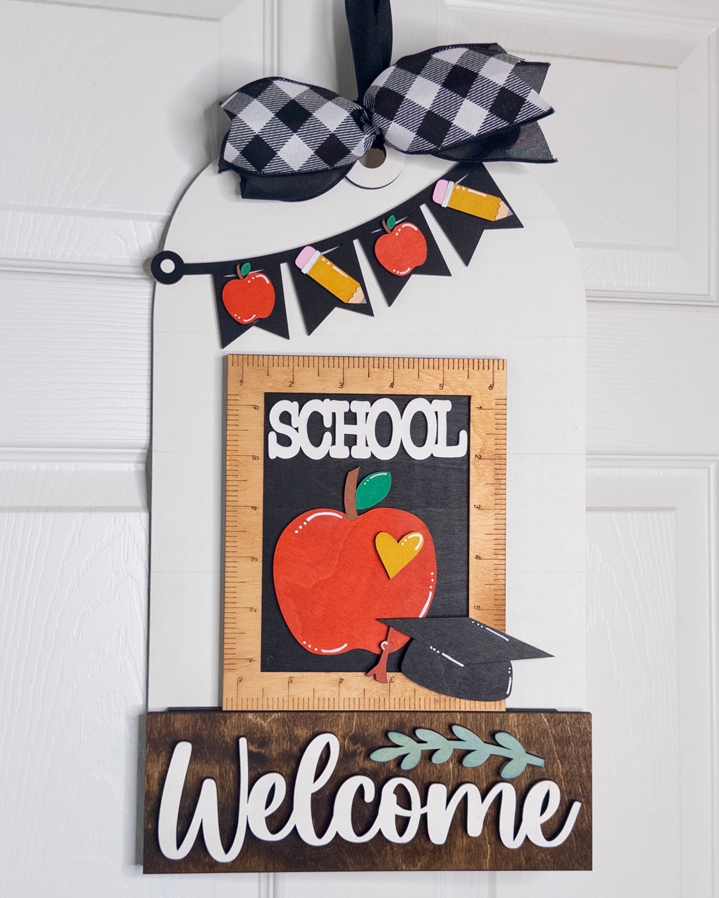 Decorative door hanger with 'School Welcome' text, apple graphic, and checkered bow on a white background.