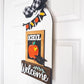 Decorative sign with 'School Welcome' text and apple illustration on a white door.