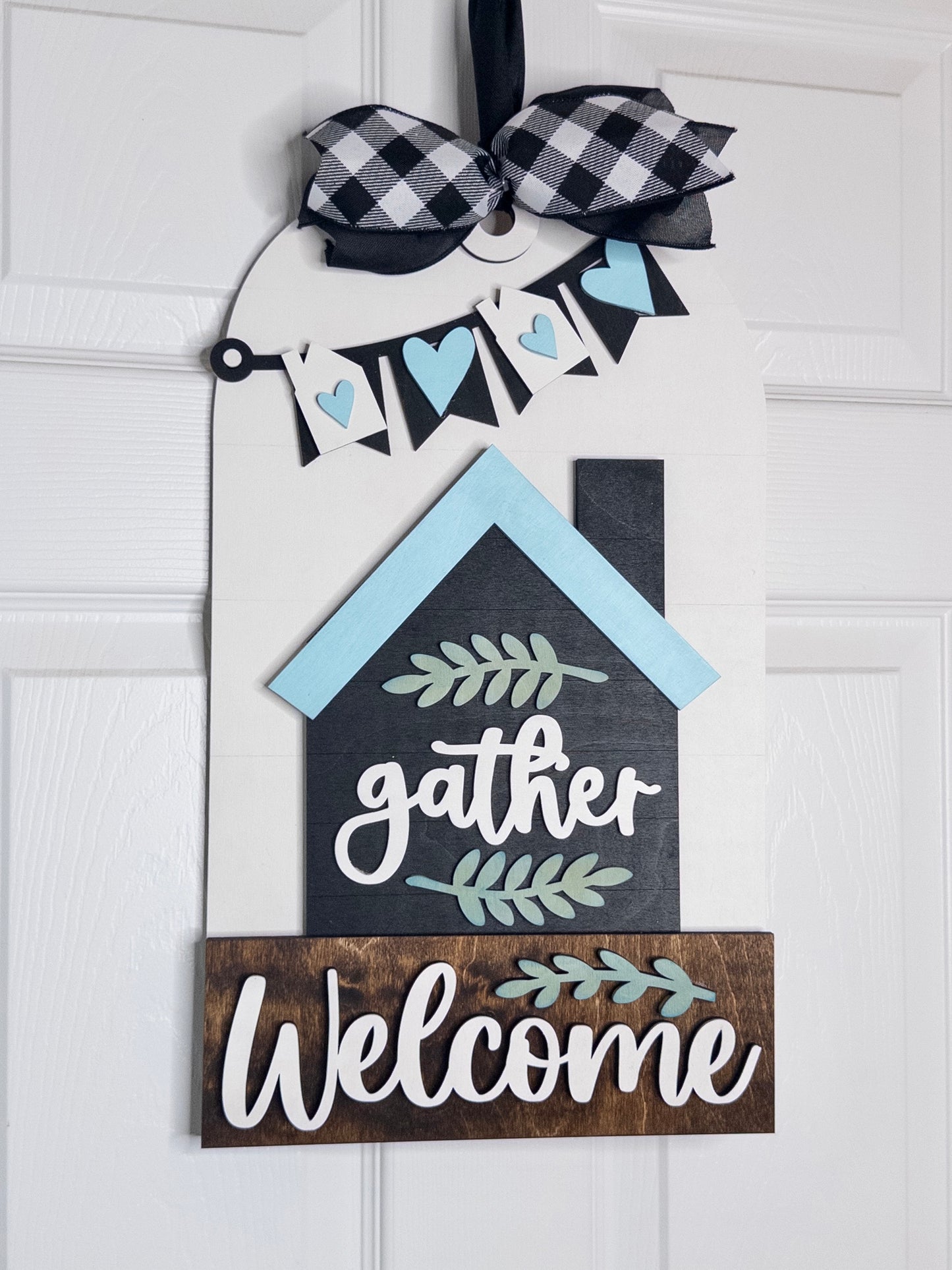 Decorative wooden sign with 'gather welcome' text on a white background