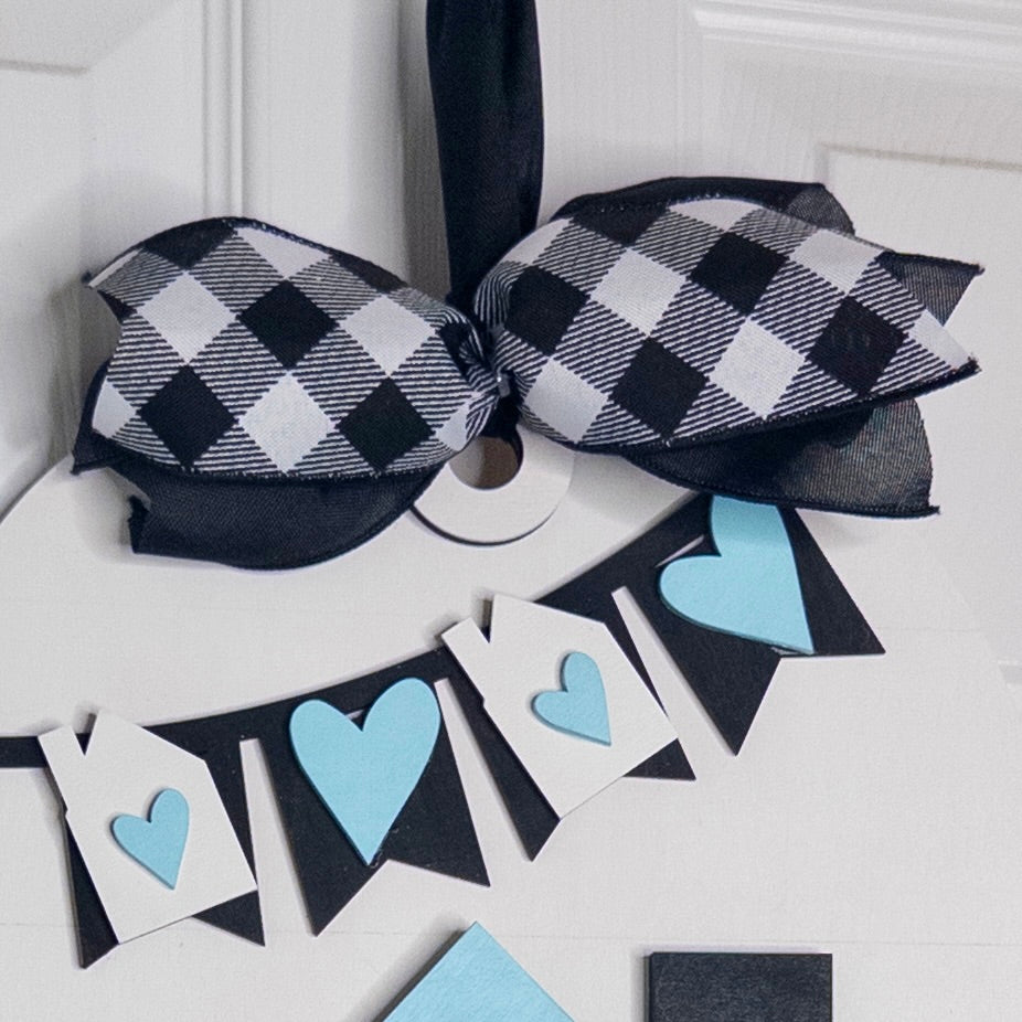 Black and white checkered bow with blue heart-shaped flags on a white background
