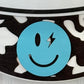 Close-up of a blue smiley face design on a black and white patterned background
