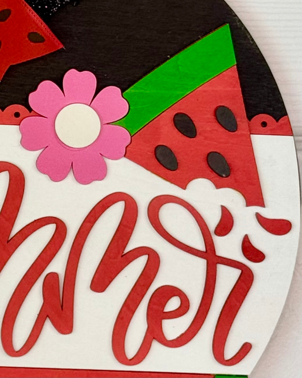 Decorative sign with watermelon slices and a flower, featuring the word 'summer'.