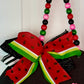 Decorative bow shaped like a watermelon with colorful beads on a white background
